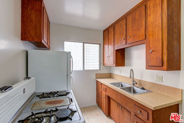 kitchen with light tile patterned floors, sink, and white appliances