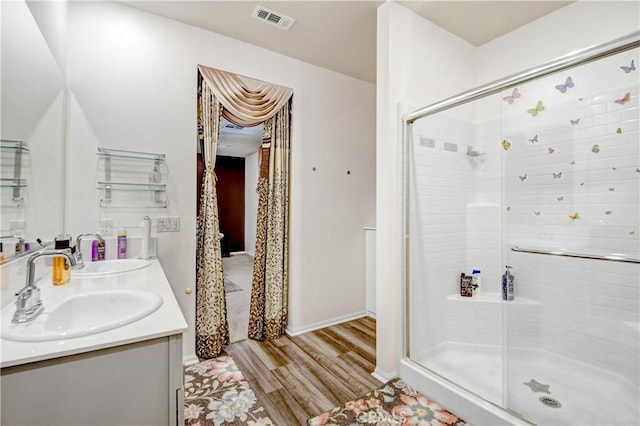 bathroom with a shower with door, vanity, and hardwood / wood-style floors