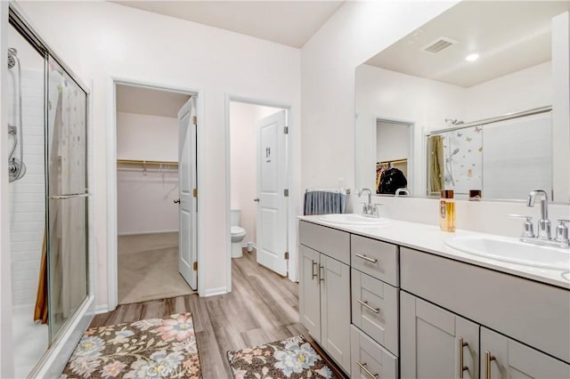 bathroom with toilet, vanity, hardwood / wood-style floors, and walk in shower