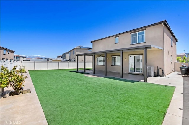 back of house featuring a lawn, a patio area, and central air condition unit