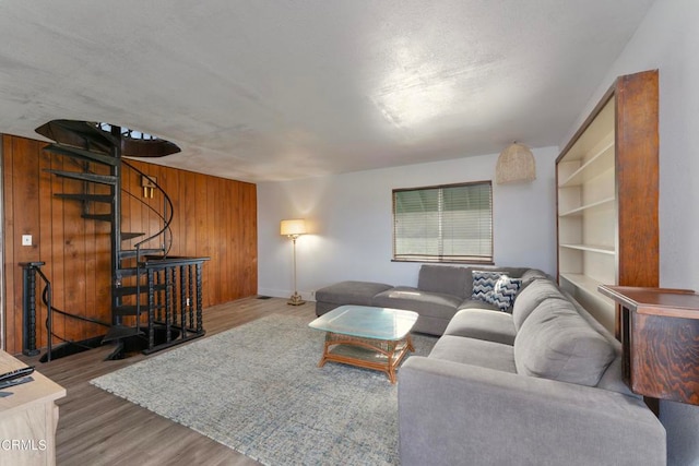 living room featuring wood-type flooring and wooden walls