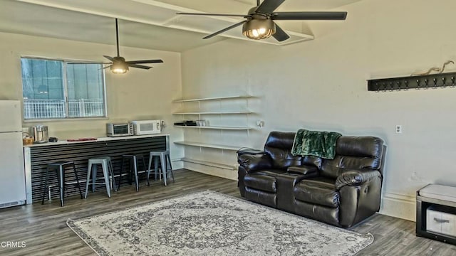 living room with ceiling fan, dark wood-type flooring, and vaulted ceiling