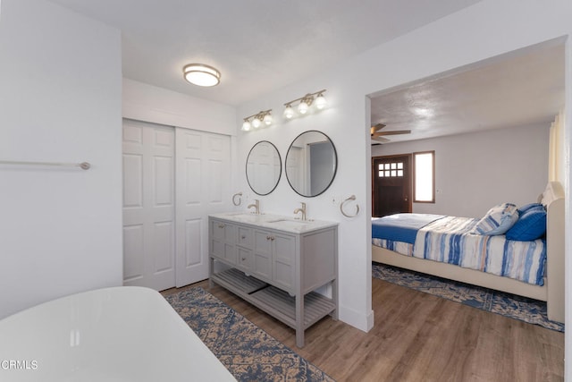 bathroom featuring vanity, a tub, hardwood / wood-style flooring, and ceiling fan