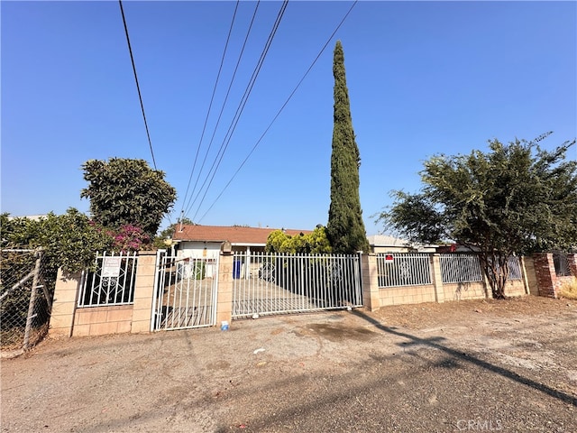 view of front of property with a fenced front yard, a gate, and concrete block siding