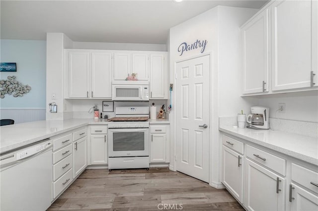 kitchen featuring white cabinetry, white appliances, and light wood-type flooring