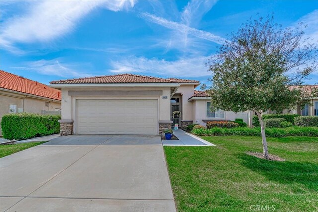 mediterranean / spanish-style house with a garage and a front lawn