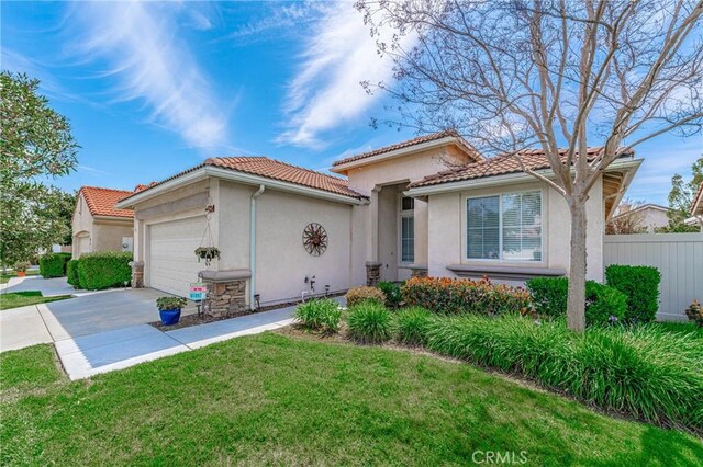 mediterranean / spanish-style house featuring a garage and a front lawn