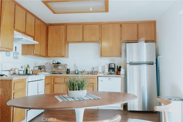 kitchen with dark wood-type flooring, white appliances, light brown cabinetry, and sink