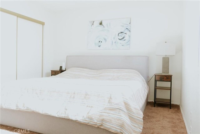 bedroom featuring a closet, baseboards, and carpet