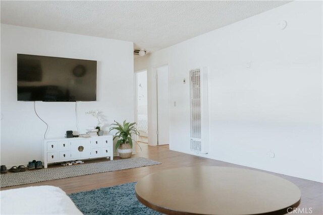 living room with a textured ceiling and light wood-type flooring