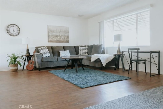 living room with wood finished floors, baseboards, and a textured ceiling