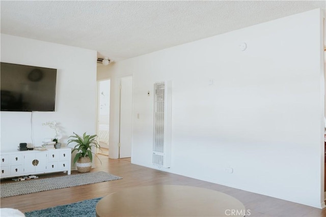 living room with a textured ceiling and light wood-type flooring