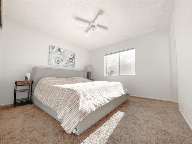 bedroom featuring light carpet, a textured ceiling, and ceiling fan