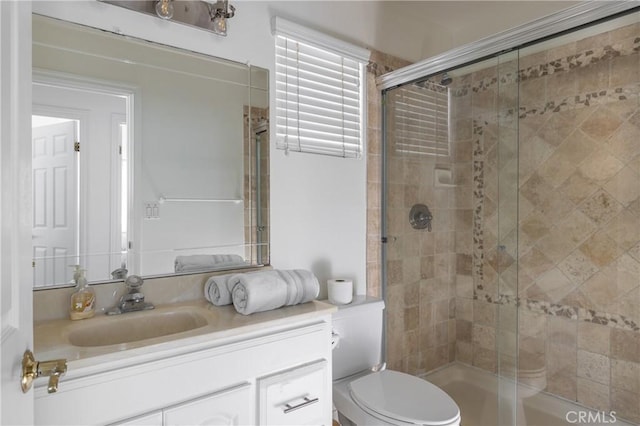 bathroom featuring vanity, toilet, and walk in shower