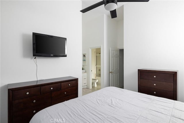 bedroom featuring ceiling fan, a towering ceiling, and connected bathroom