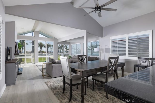 dining area featuring vaulted ceiling with beams, light hardwood / wood-style floors, plenty of natural light, and ceiling fan