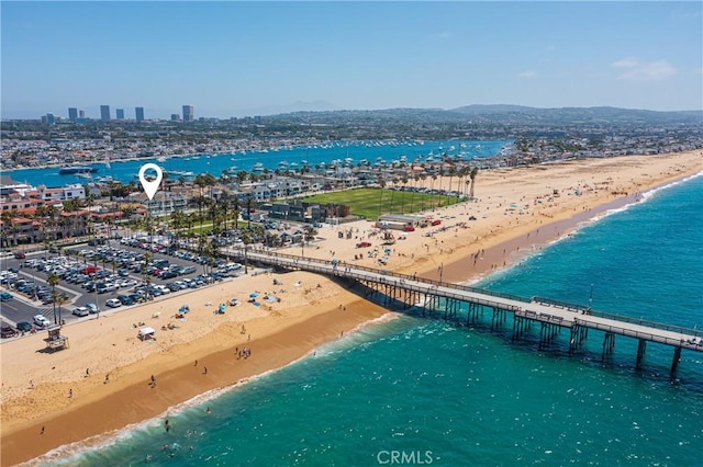 birds eye view of property with a water view and a beach view