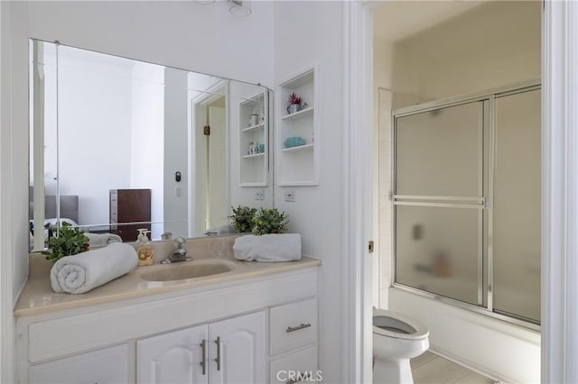 full bathroom featuring vanity, toilet, and combined bath / shower with glass door