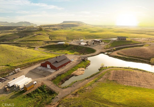 aerial view at dusk featuring a water view and a rural view