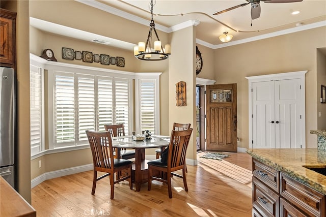 dining room featuring light hardwood / wood-style flooring, ornamental molding, and ceiling fan with notable chandelier