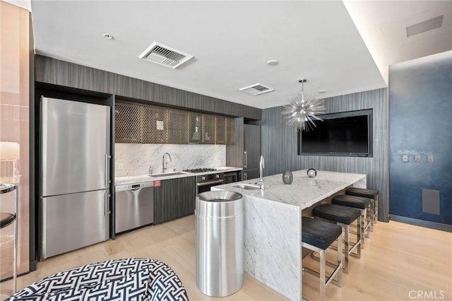 kitchen featuring decorative light fixtures, a center island, sink, and appliances with stainless steel finishes