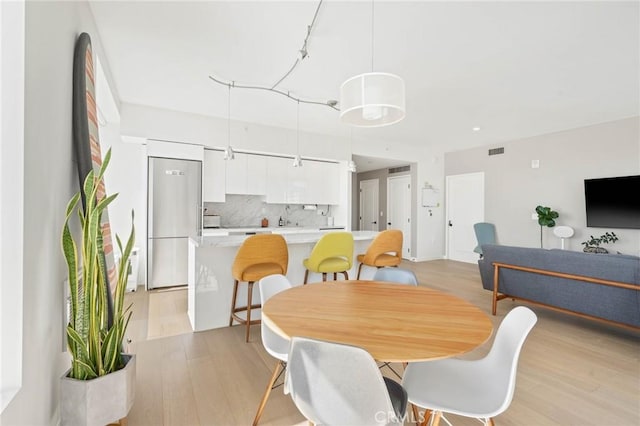 dining space with sink and light hardwood / wood-style floors