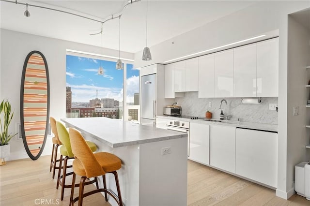 kitchen with white cabinets, a center island, pendant lighting, and sink