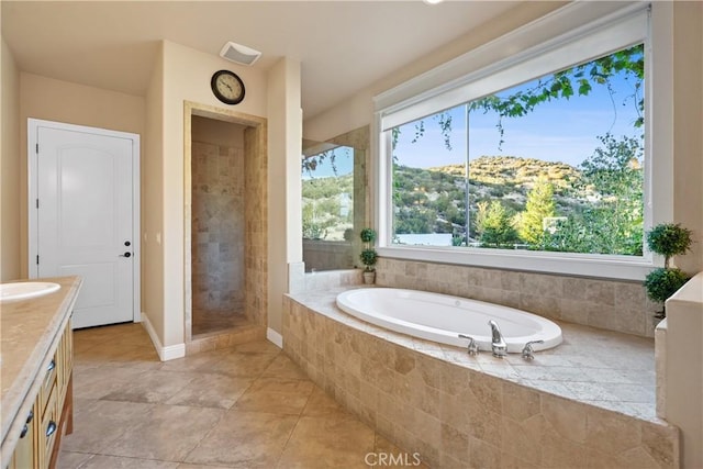 bathroom with a mountain view, vanity, and separate shower and tub