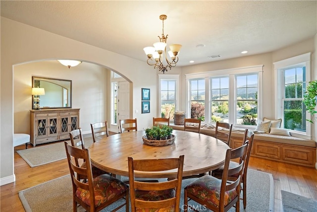 dining area featuring light wood-type flooring and a notable chandelier