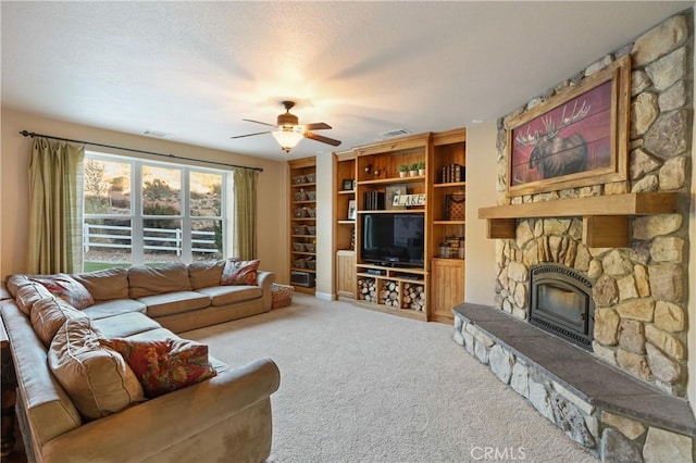 carpeted living room featuring ceiling fan and a fireplace