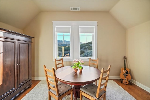 dining space with lofted ceiling and hardwood / wood-style flooring