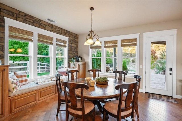 dining space with dark hardwood / wood-style floors, a chandelier, and plenty of natural light