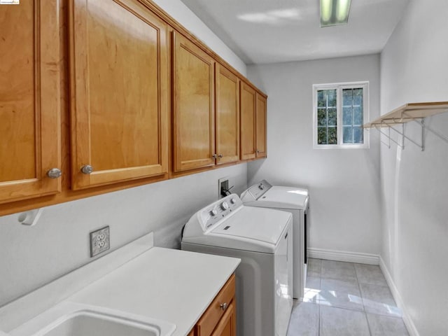 clothes washing area featuring sink, independent washer and dryer, light tile patterned flooring, and cabinets