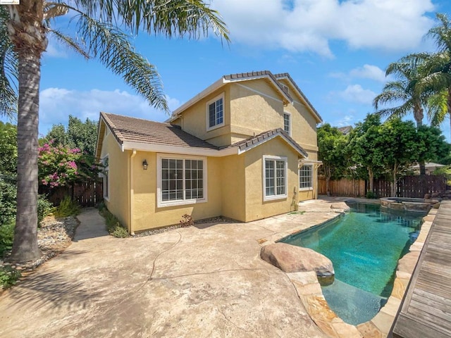 rear view of property with a patio and a fenced in pool