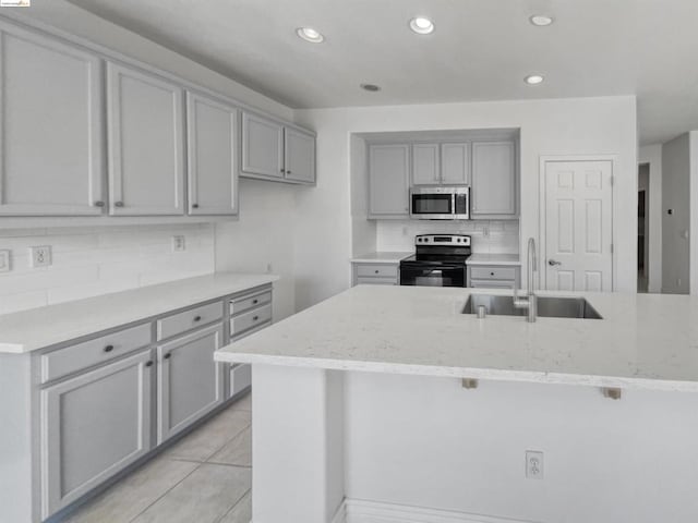 kitchen featuring light tile patterned floors, stainless steel appliances, sink, and gray cabinets