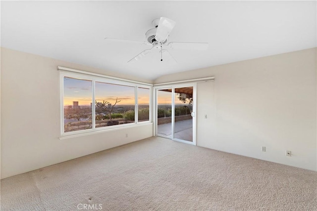 carpeted spare room featuring ceiling fan