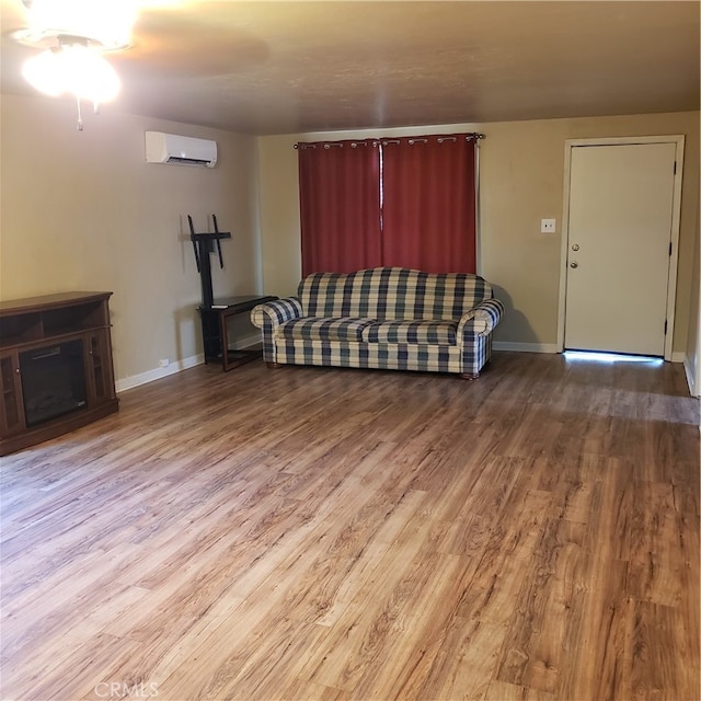 unfurnished living room with wood-type flooring, an AC wall unit, and ceiling fan