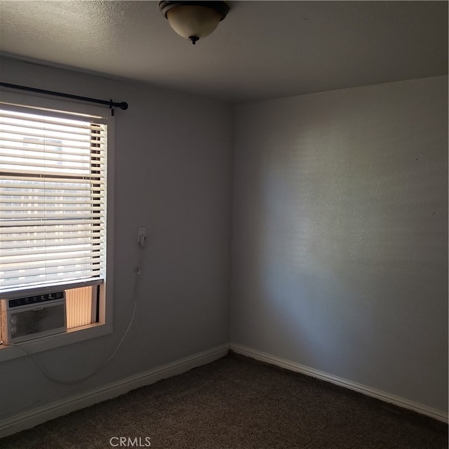 empty room featuring dark carpet and cooling unit