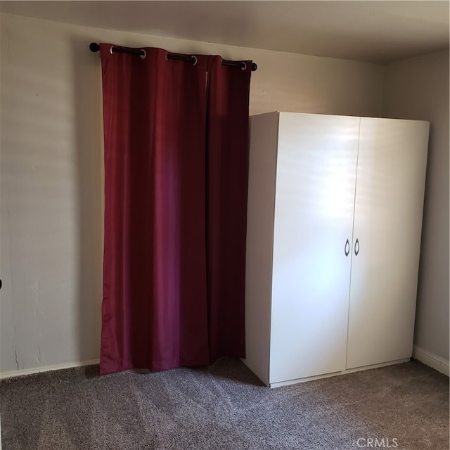 unfurnished bedroom featuring dark colored carpet