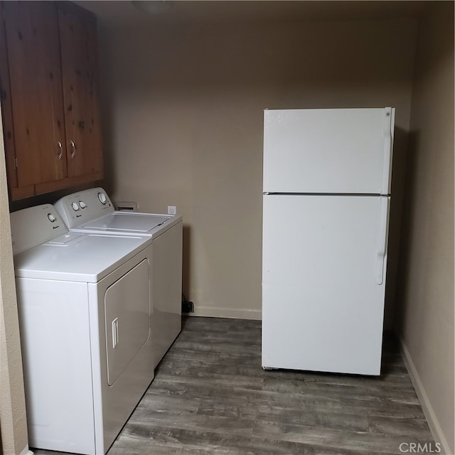 washroom featuring separate washer and dryer, dark hardwood / wood-style floors, and cabinets