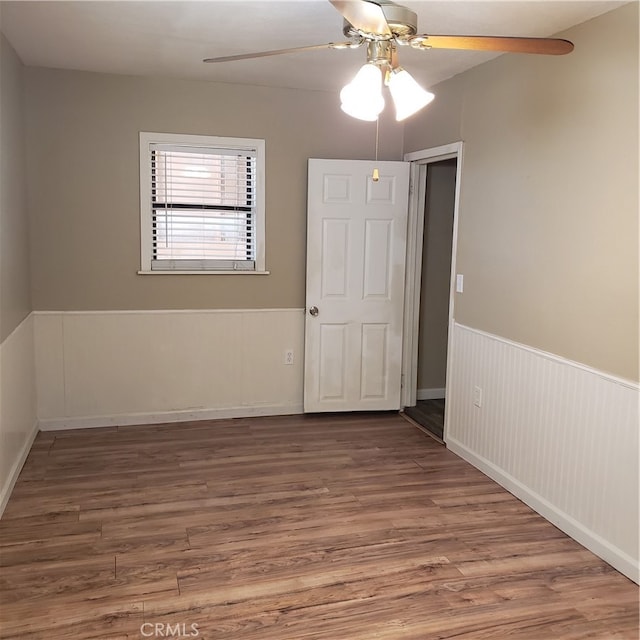 empty room with ceiling fan and hardwood / wood-style floors