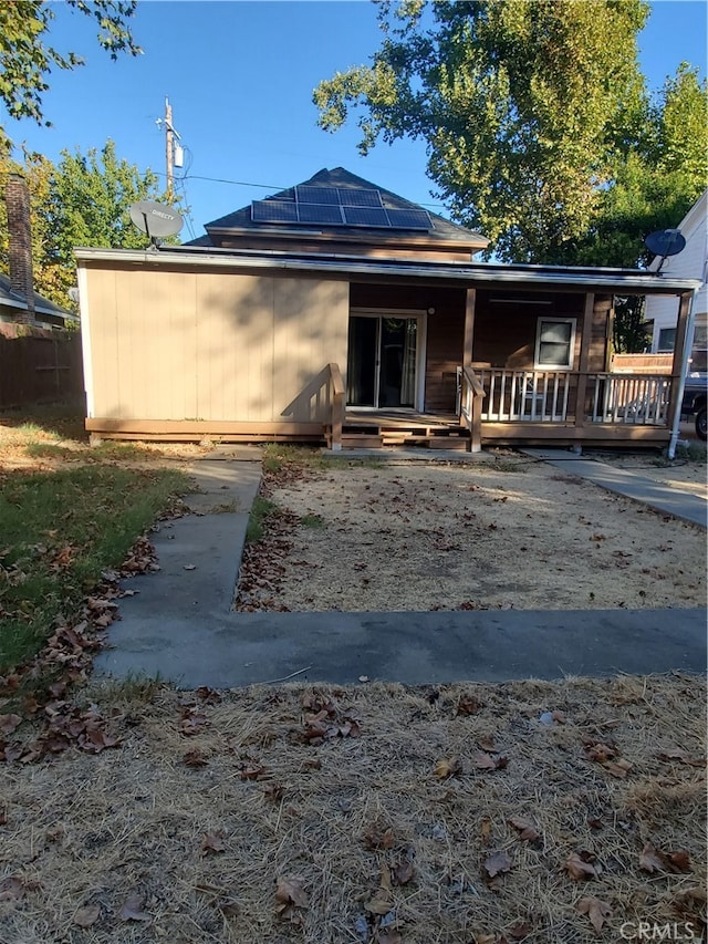 back of property featuring solar panels and a porch