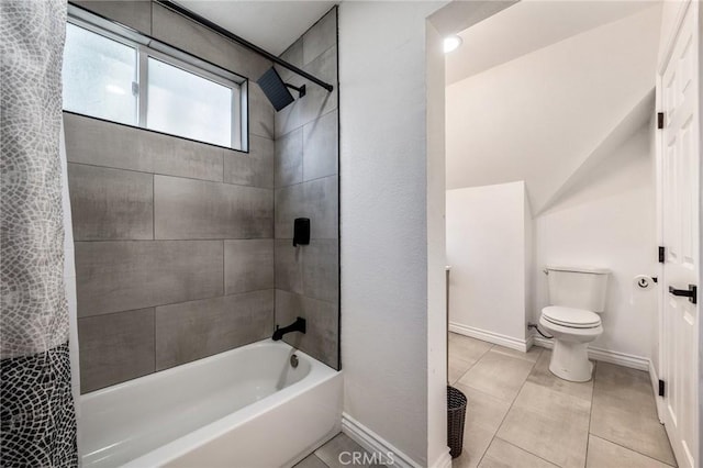 bathroom featuring tile patterned flooring, tiled shower / bath combo, and toilet