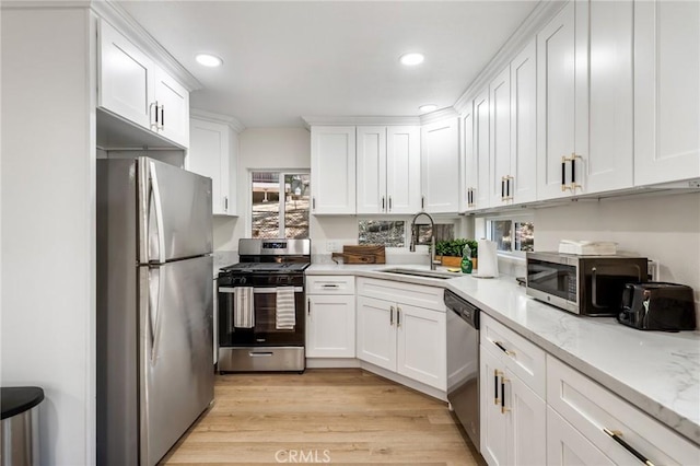 kitchen with light hardwood / wood-style floors, white cabinetry, and appliances with stainless steel finishes