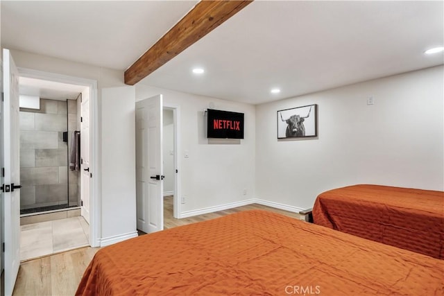 bedroom featuring beam ceiling, ensuite bathroom, and light wood-type flooring