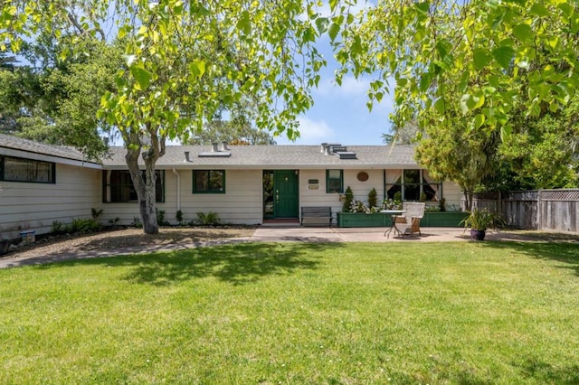 rear view of property featuring a patio and a lawn