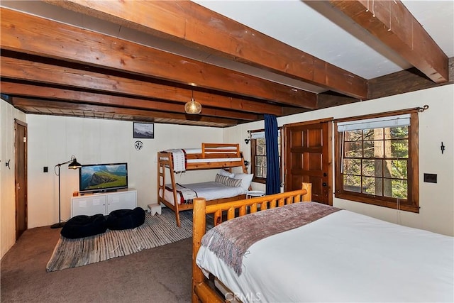 carpeted bedroom with beamed ceiling