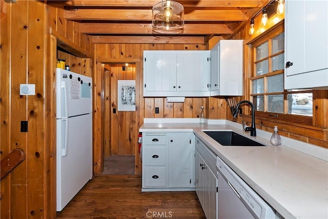 kitchen featuring white appliances, white cabinets, sink, beamed ceiling, and dark hardwood / wood-style flooring