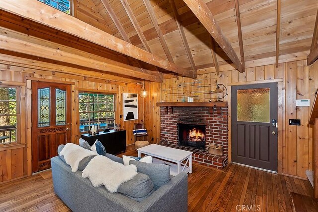 living room featuring hardwood / wood-style flooring, vaulted ceiling with beams, wood ceiling, and a brick fireplace