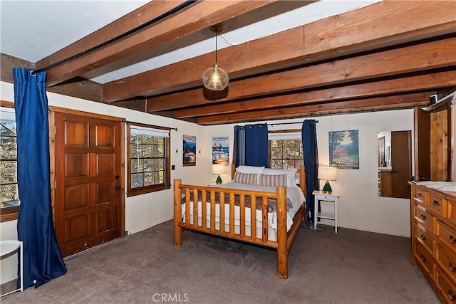 bedroom featuring beamed ceiling and dark colored carpet